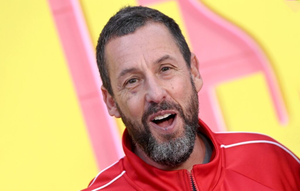 Adam Sandler wears socks when he goes swimming because “he can’t bend to take them off”